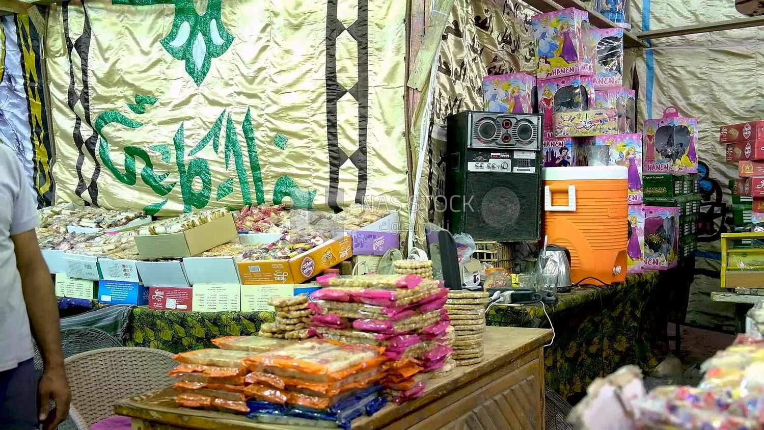 Man sitting at a desk selling the candies of the prophet Muhammad&#39;s birth in the street