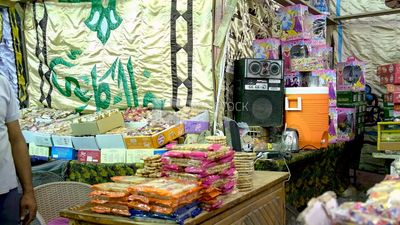 Man sitting at a desk selling the candies of the prophet Muhammad&#39;s birth in the street