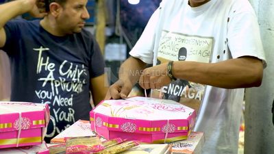Man ties the box of the candies of Prophet Muhammad&#39;s Birth to sell it