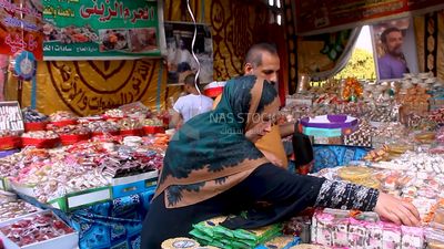 Man helps a woman buy the candies of the prophet Muhammad&#39;s birth on the street
