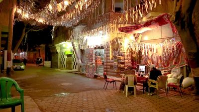 Women sitting in the street watching the television, street, ramadan decorations