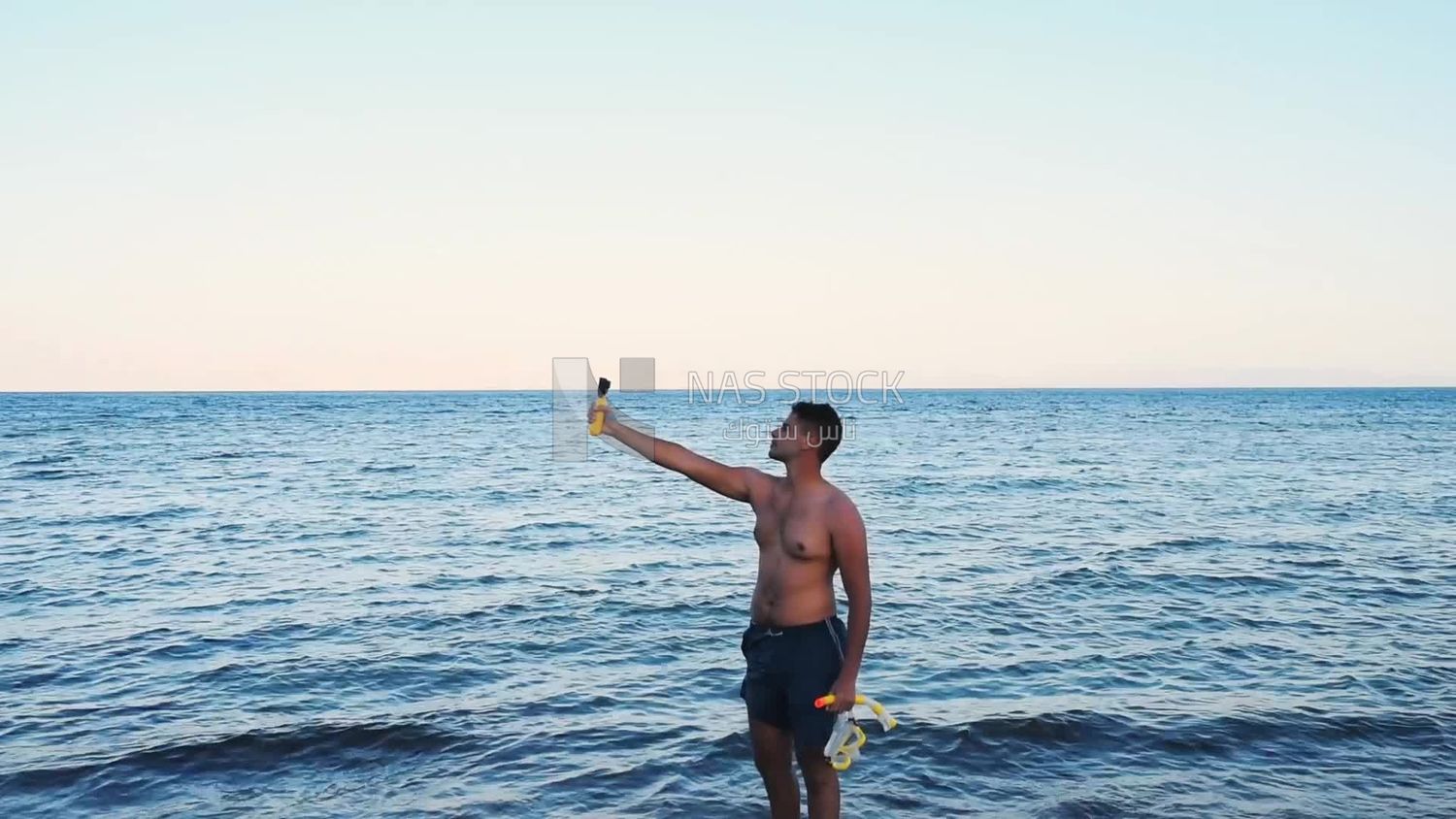 Young man taking a selfie on the beach