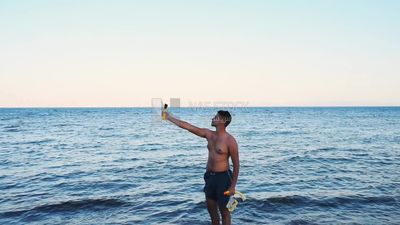 Young man taking a selfie on the beach