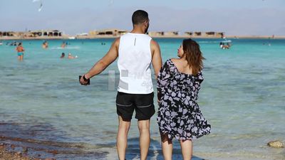 زوجان يستمتعان بمنظر البحر و الهواء المنعش فى المنتجع السياحى