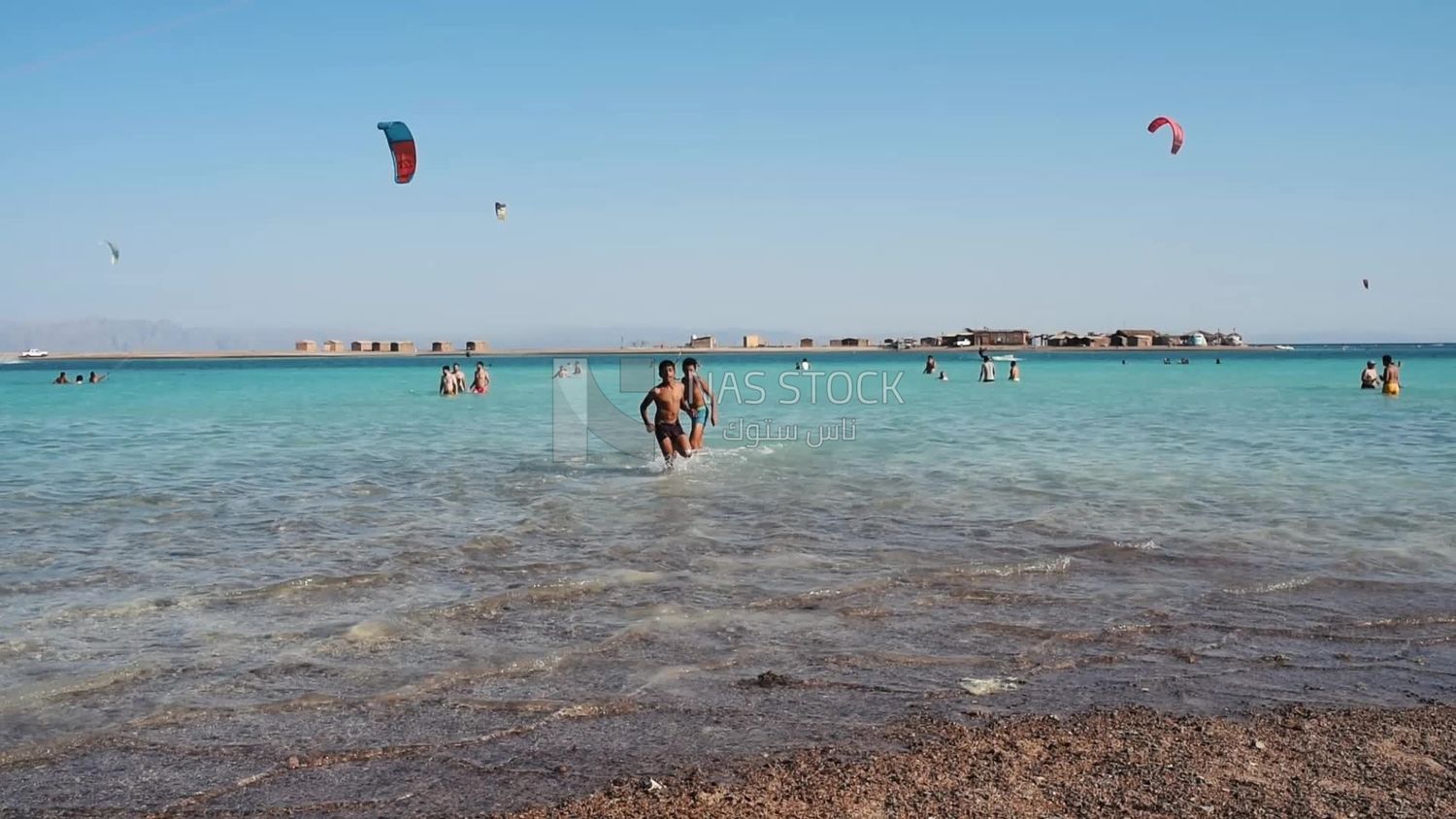 Two children running on the beach and in the sea