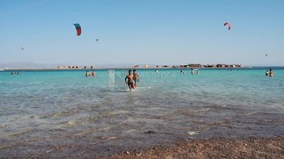 Two children running on the beach and in the sea