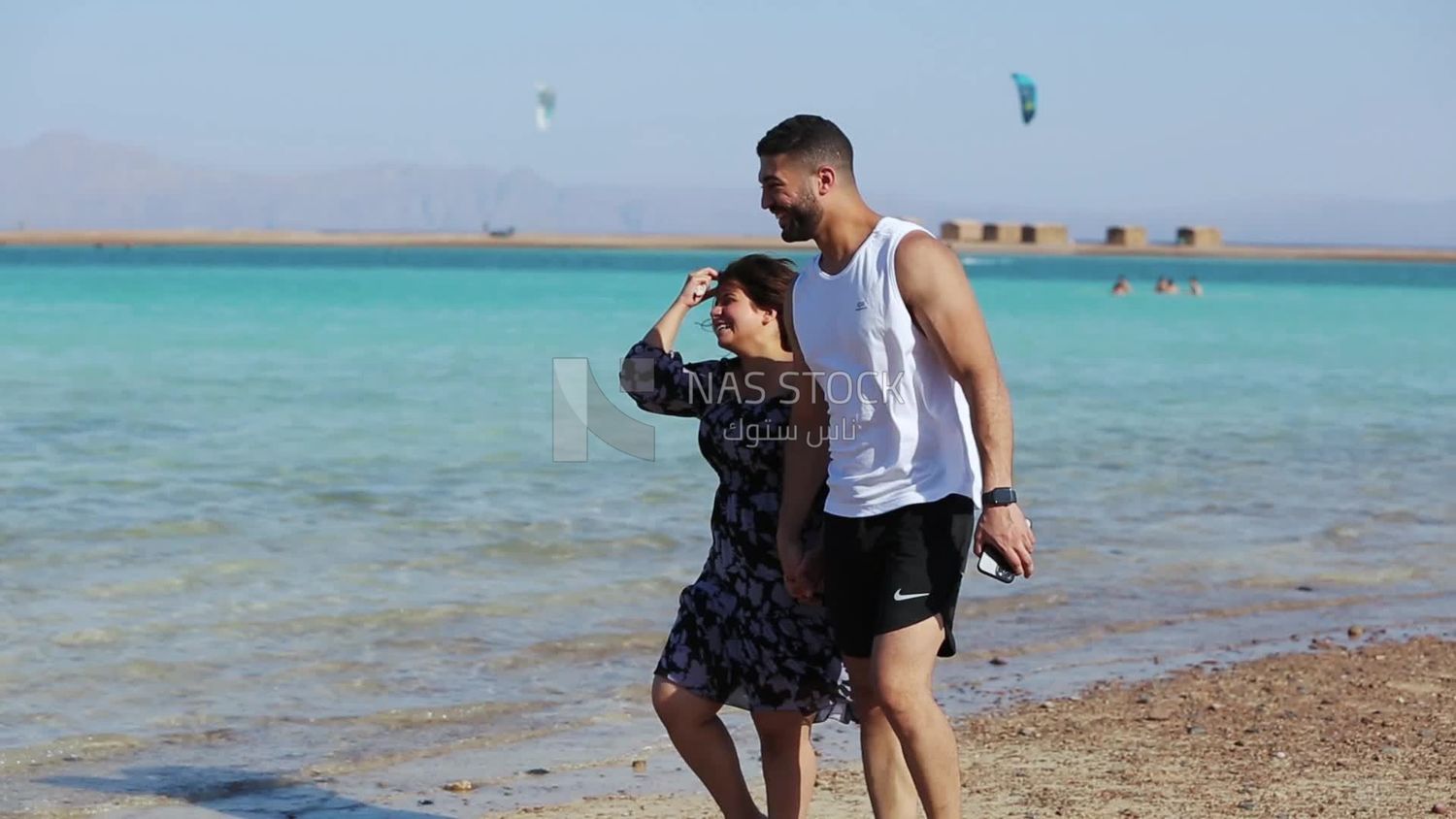 Couple walking in unison on the seashore