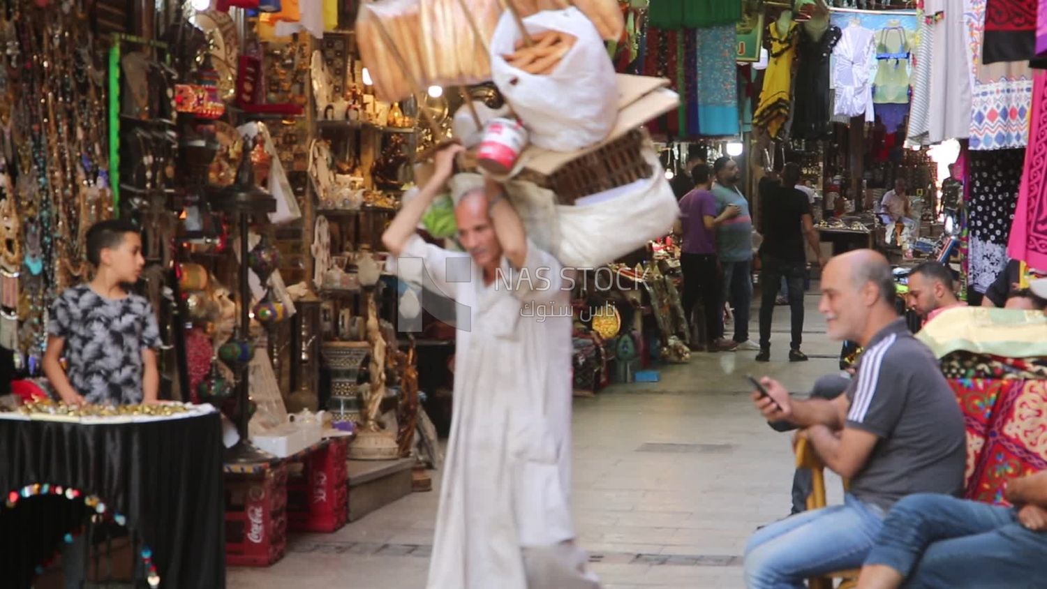 بائع متجول يبيع المخبوزات في شارع المعز. يعد الشارع أيضًا موطنًا للعديد من الأسواق والبازارات ، حيث يمكن للزوار التسوق لشراء الهدايا التذكارية والتوابل والمنسوجات ، وتجربة الطاقة النابضة بالحياة في شارع القاهرة الصاخب.