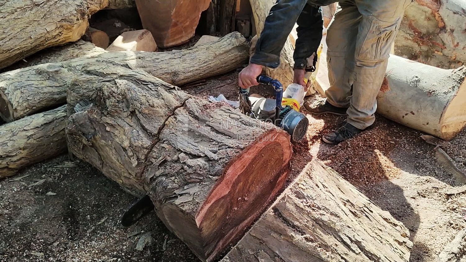 Craftsman in a wood cutting workshop is shaping one of the wooden pieces