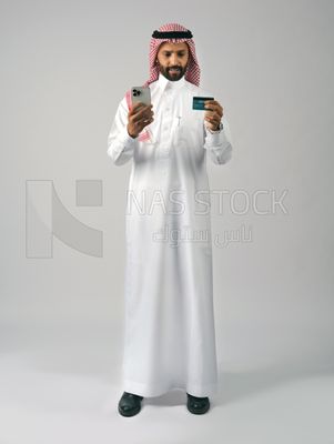 رجل خليجي يمسك بيده الجوال ،