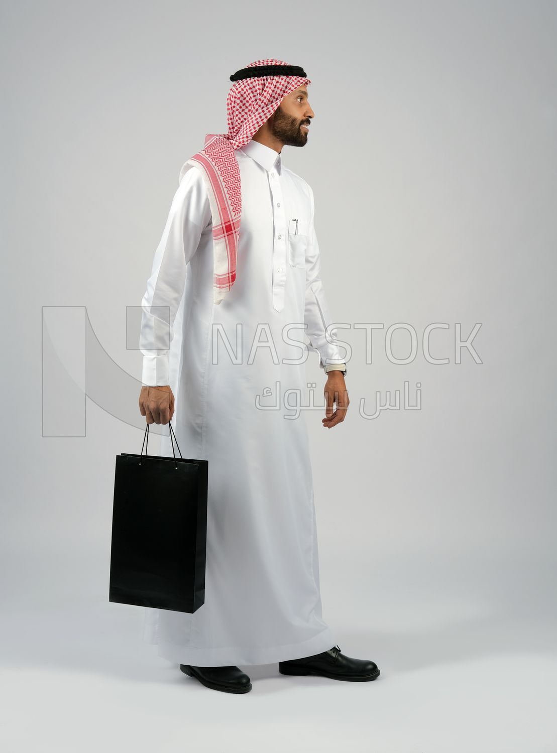 Gulf man holding a shopping bag