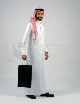 Gulf man holding a shopping bag