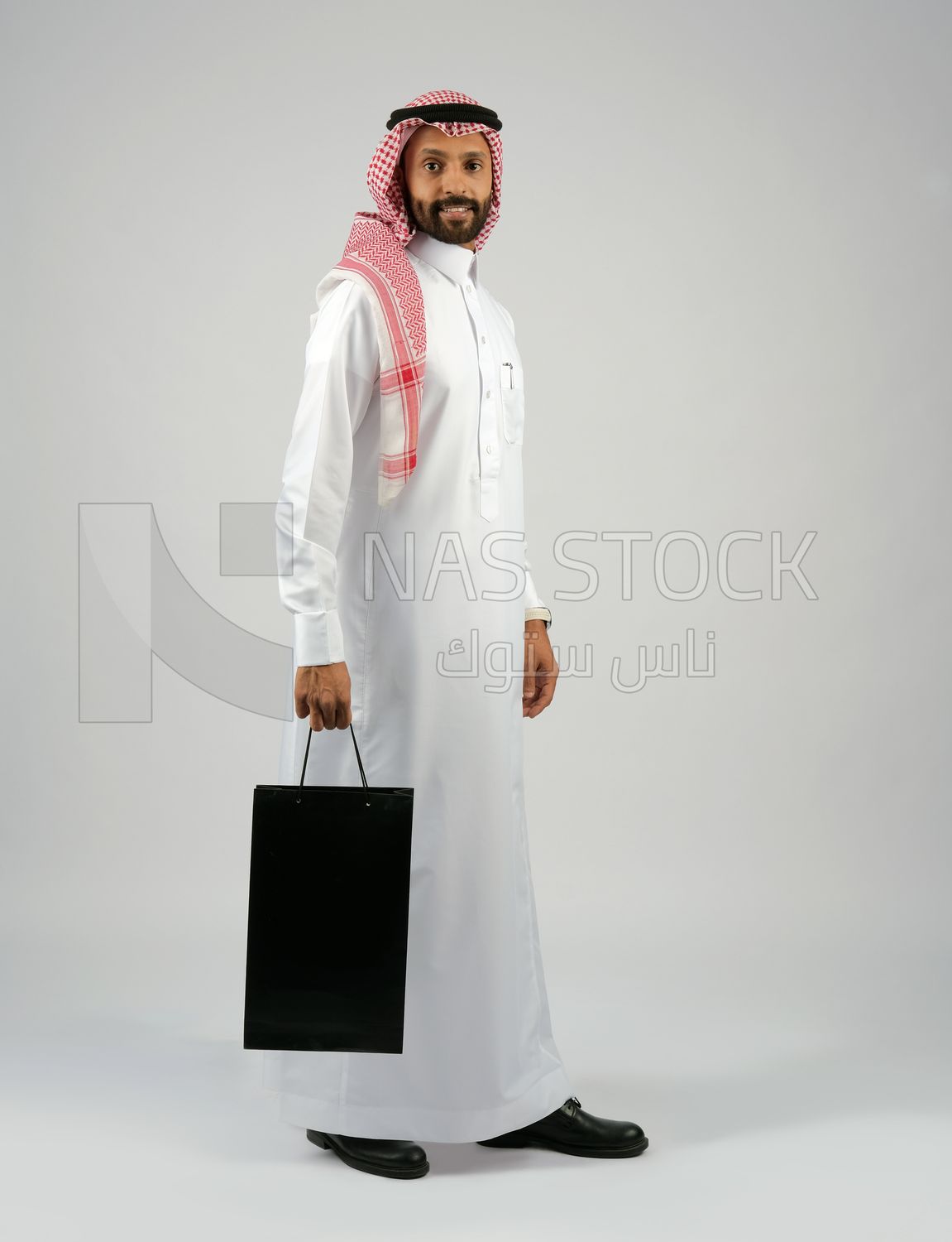 Gulf man holding a shopping bag