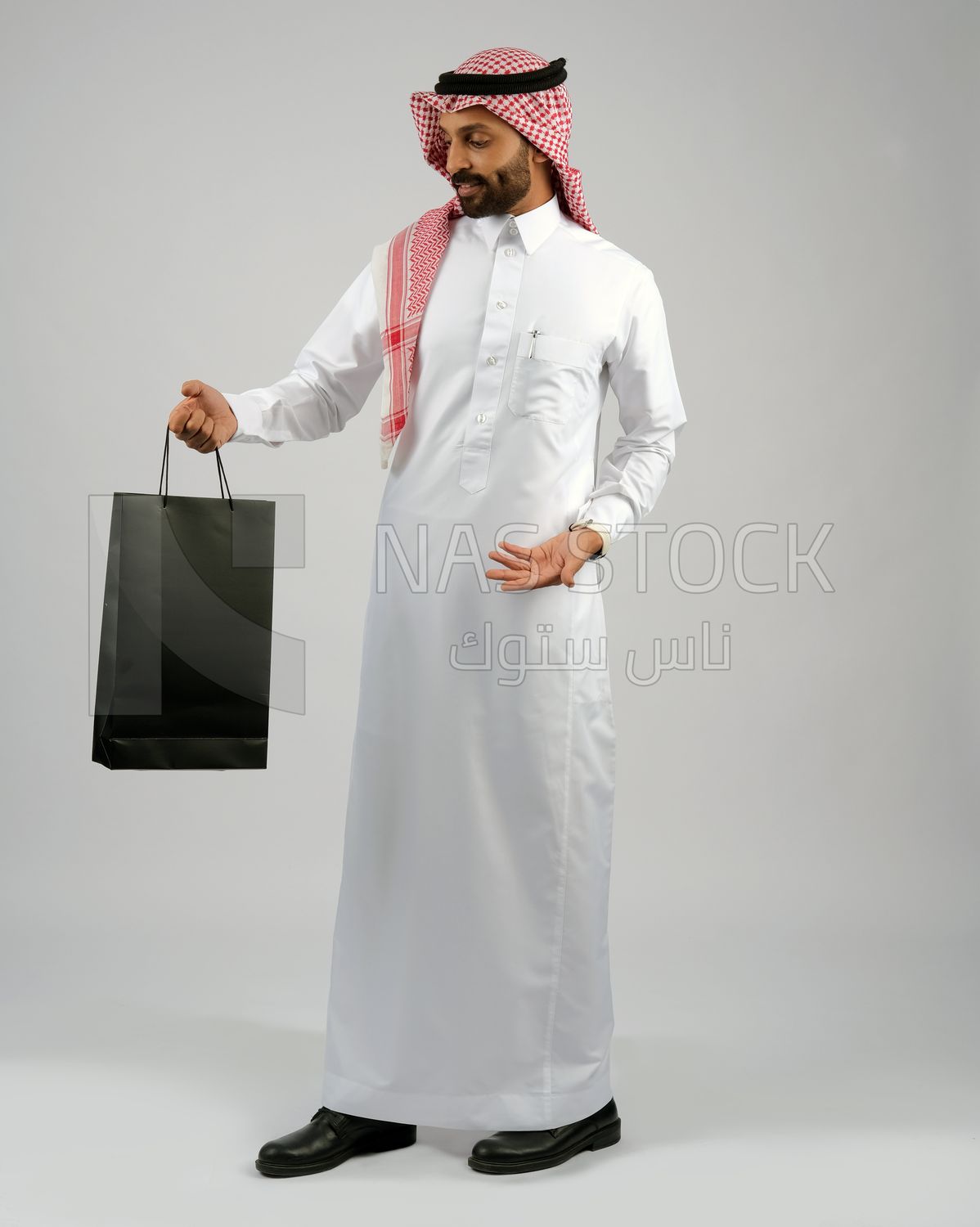 Gulf man holding a shopping bag
