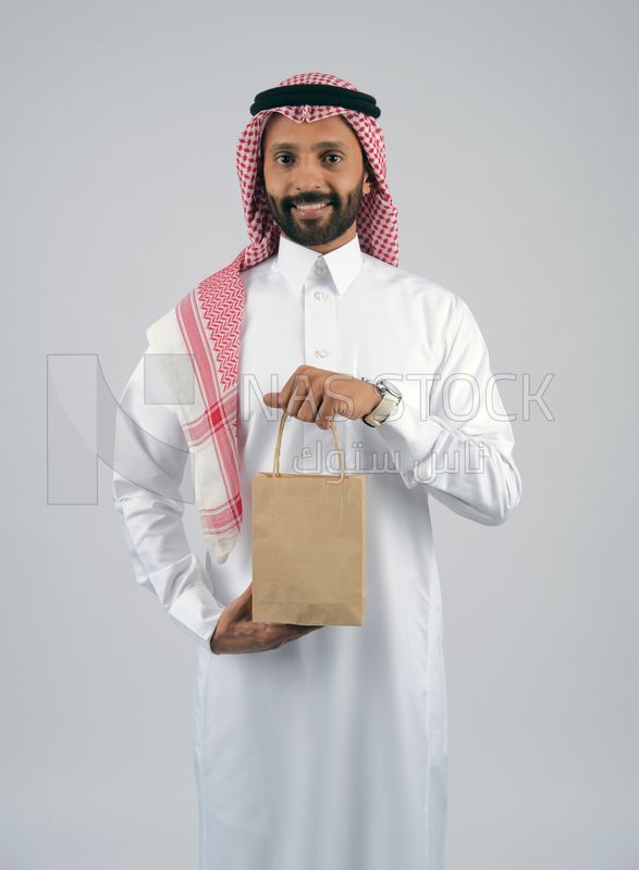 Gulf man holding a shopping bag