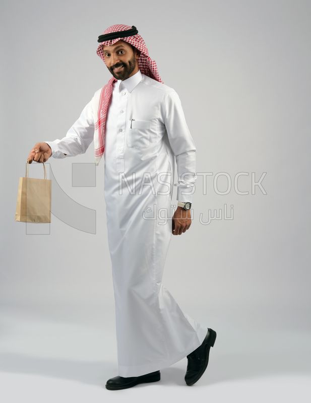 Gulf man holding a shopping bag