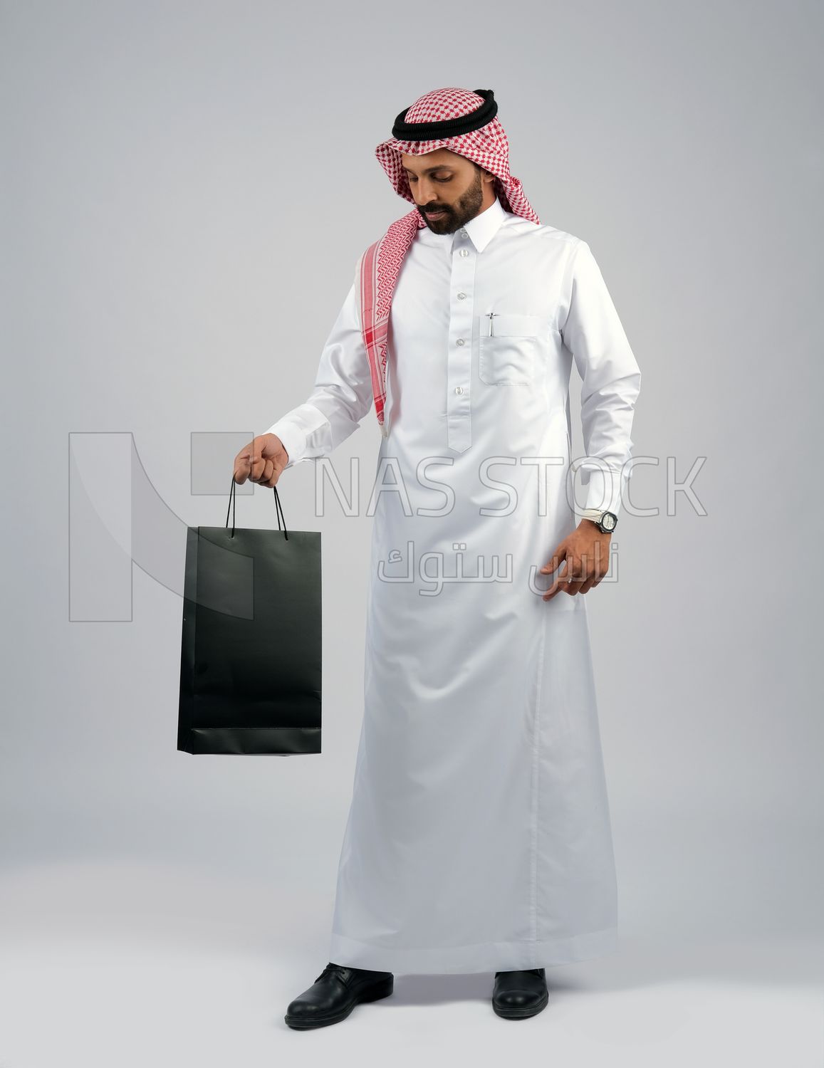 Gulf man holding a shopping bag