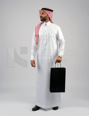 Gulf man holding a shopping bag