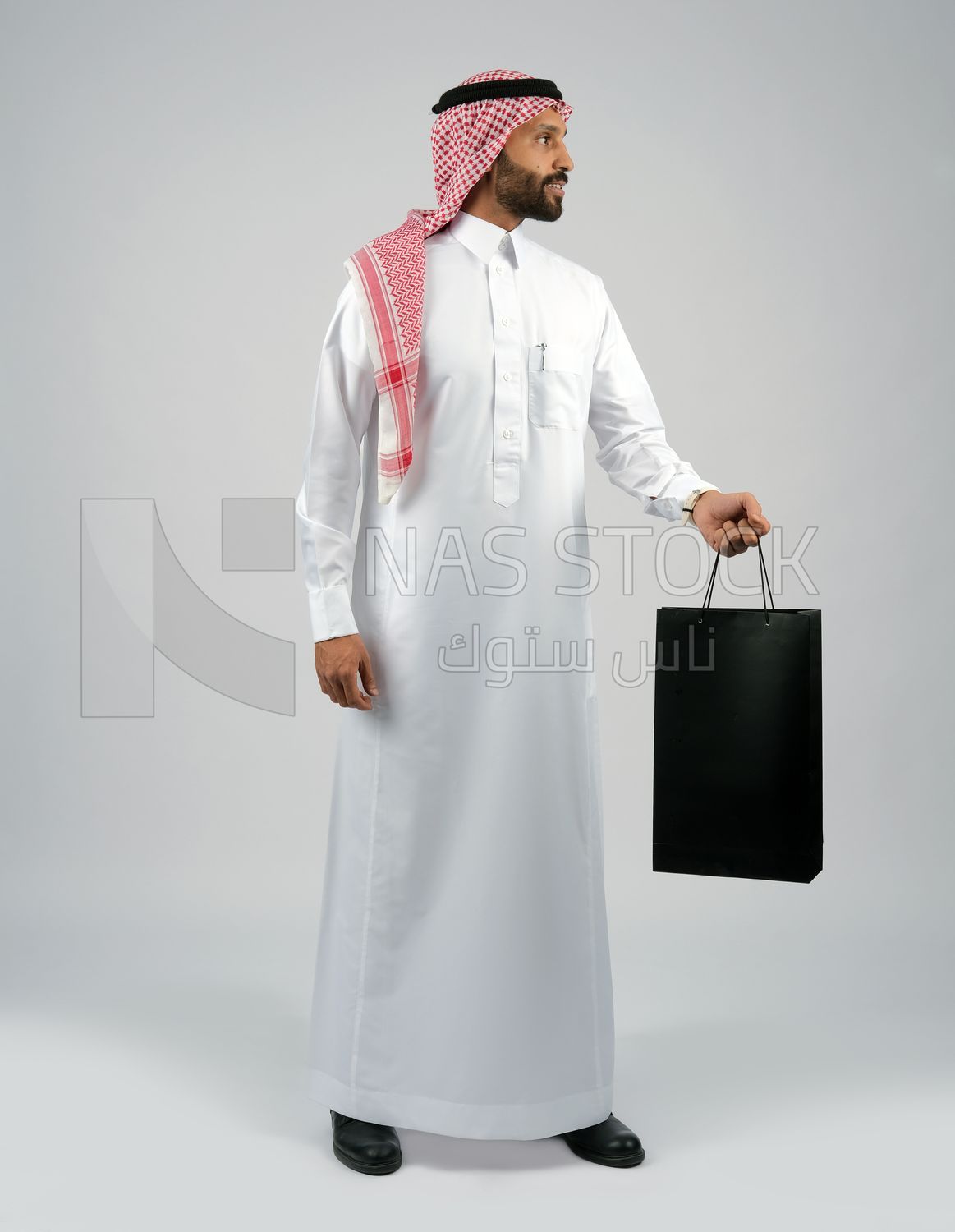 Gulf man holding a shopping bag