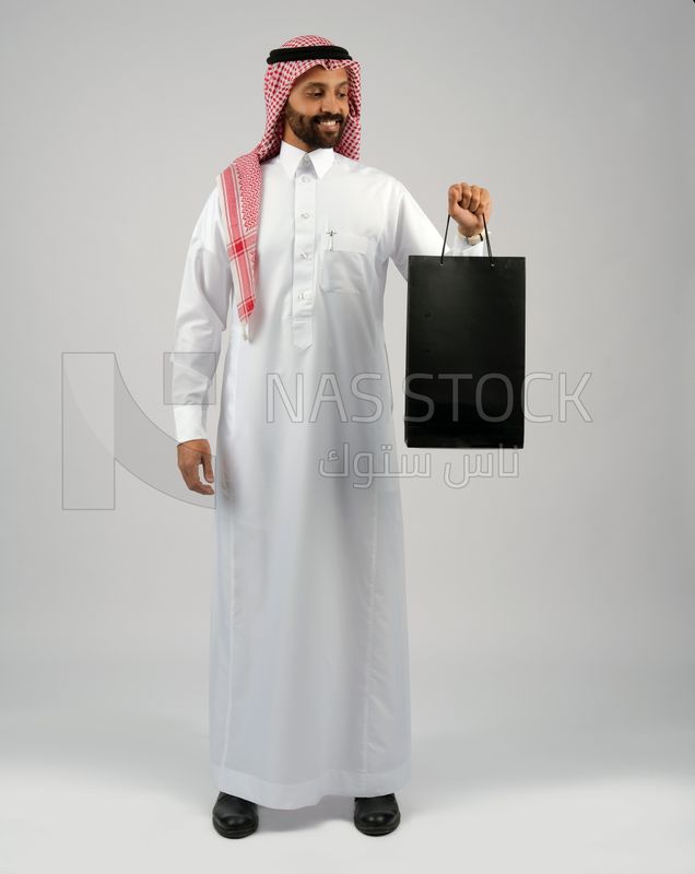 Gulf man holding a shopping bag