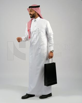 Gulf man holding a shopping bag