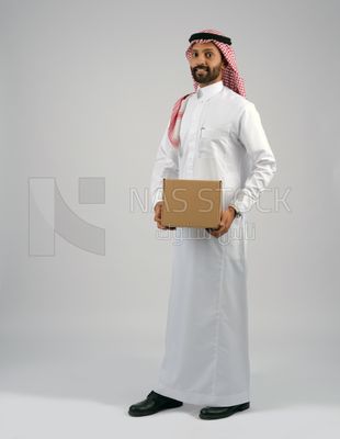 رجل خليجي يحمل بيده صندوق كرتوني