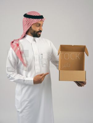 رجل خليجي يحمل بيده صندوق كرتوني