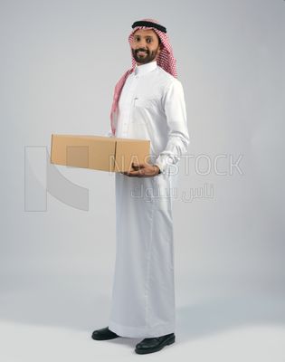 رجل خليجي يحمل بيده صندوق كرتوني