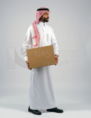 رجل خليجي يحمل بيده صندوق كرتوني