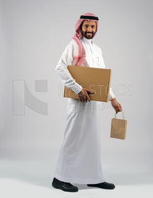 رجل خليجي يحمل بيده صندوق كرتوني