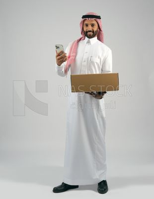 رجل خليجي يحمل بيده صندوق كرتوني