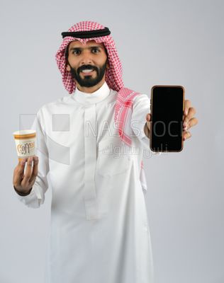 Gulf man holding a Mobile phone and coffee cup