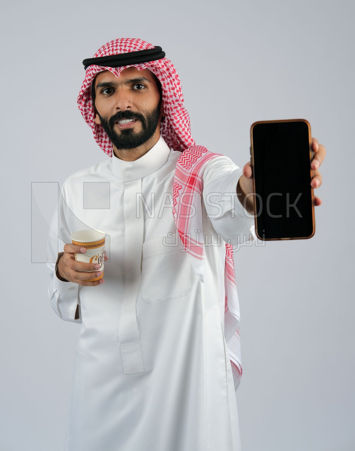 Gulf man holding a Mobile phone and coffee cup