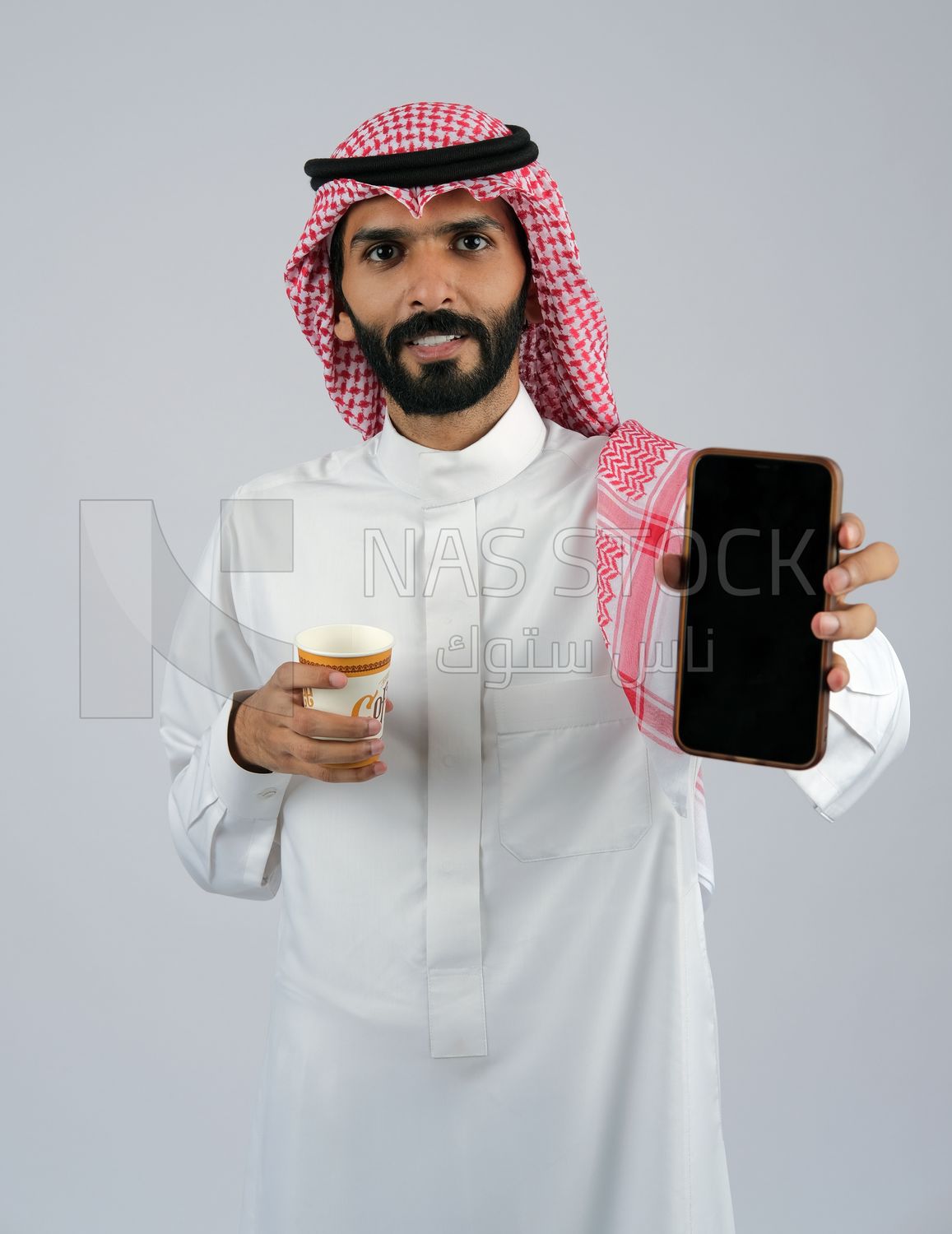 Gulf man holding a Mobile phone and coffee cup