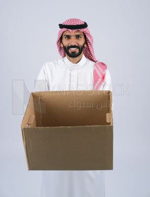منظر امامى لرجل خليجي سعودي مبتسم وسعيد يحمل صندوق فارغ  ، اعمال خيرية ، تبرعات وعطاءات ، جمعيات خيرية للمحتاجين ، مبادرات انسانية ، توصيل الطلبات والبضائع ,الشحن والتوصيل