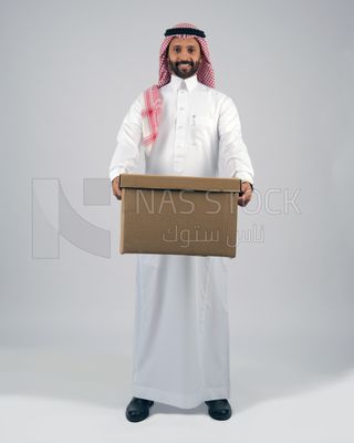 منظر امامى لرجل خليجي سعودي مبتسم وسعيد يحمل صندوق فارغ  ، اعمال خيرية ، تبرعات وعطاءات ، جمعيات خيرية للمحتاجين ، مبادرات انسانية ، توصيل الطلبات والبضائع ,الشحن والتوصيل