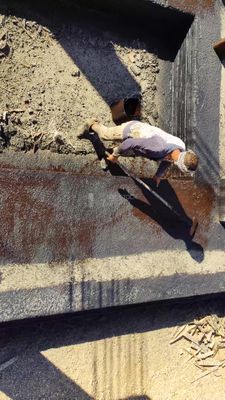 Worker paints a fence brown at a construction site