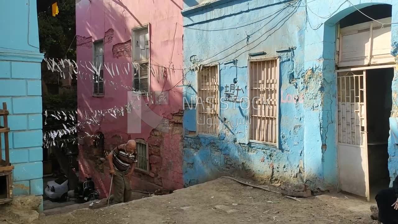 رجل مسن يصعد السلم بصعوبة فى احد المناطق الشعبية بمصر