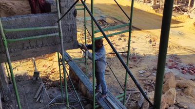 Worker paints buildings with cement