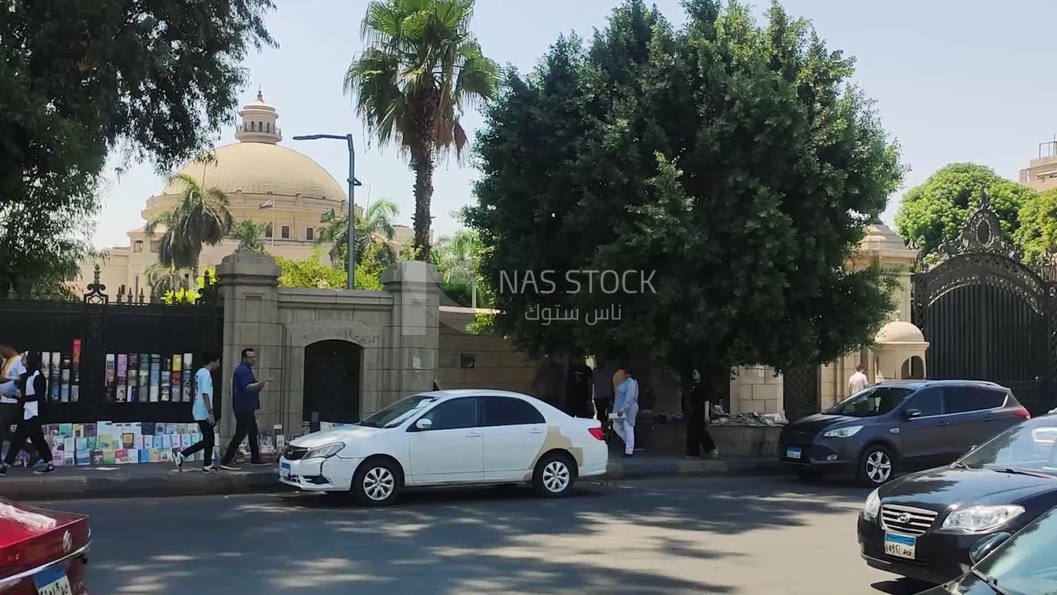 Side door of one of the doors of Cairo University with a man selling books on the sidewalk