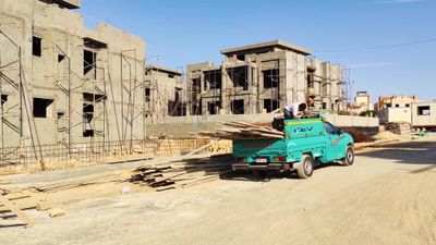 Worker unload a shipment of lumber into a construction site for use