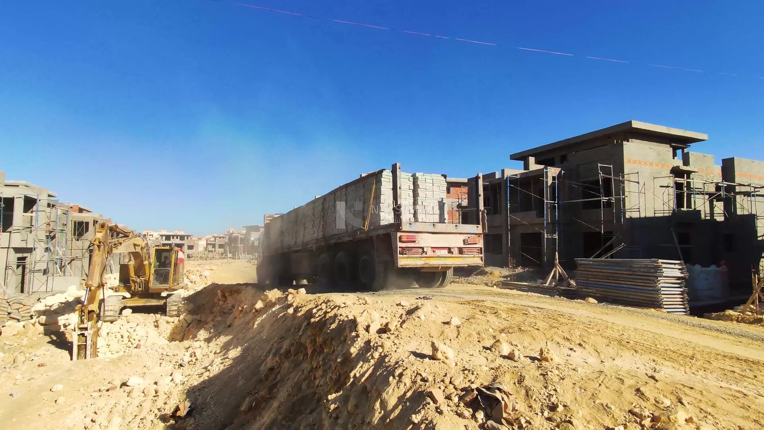 Truck loaded with white bricks and concrete materials inside a construction site