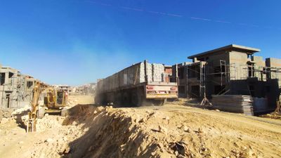 Truck loaded with white bricks and concrete materials inside a construction site