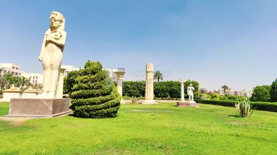 Wide green garden with trees and statues
