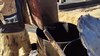 Worker mobilizes water for use in mixing cement and sand
