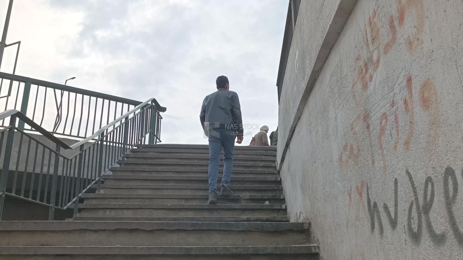 Video showing a man climbing the stairs of a pedestrian bridge