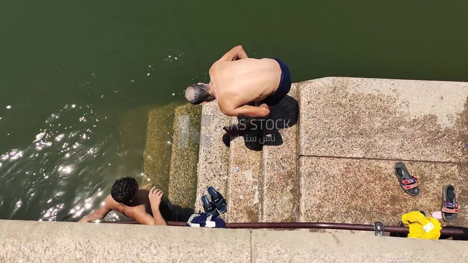 Man is using sunscreen in preparation for swimming in the Nile