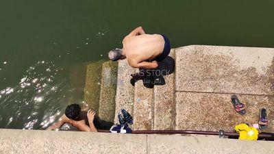 Man is using sunscreen in preparation for swimming in the Nile