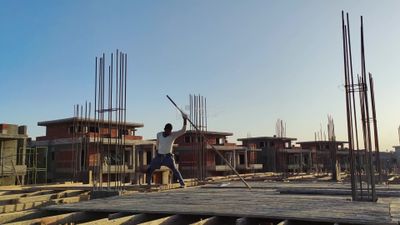 Worker installs wooden planks to form a wooden structure into which cement is poured