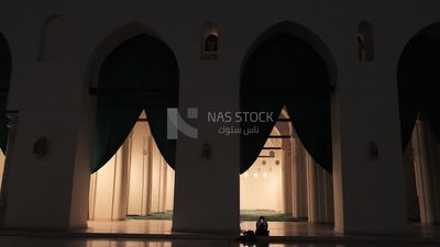سيدة تجلس على الارض ممسكة بجوالها بمسجد الحكيم بأمر الله ، السياحة في مصر ، سياح ، مساجد مشهورة في مصر.